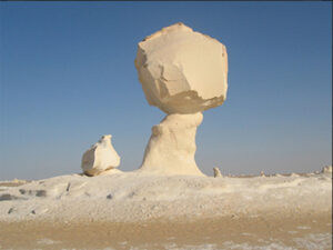 Against the backdrop of a cloudless sky, mushroom-shaped limestone formations stand out in the White Desert