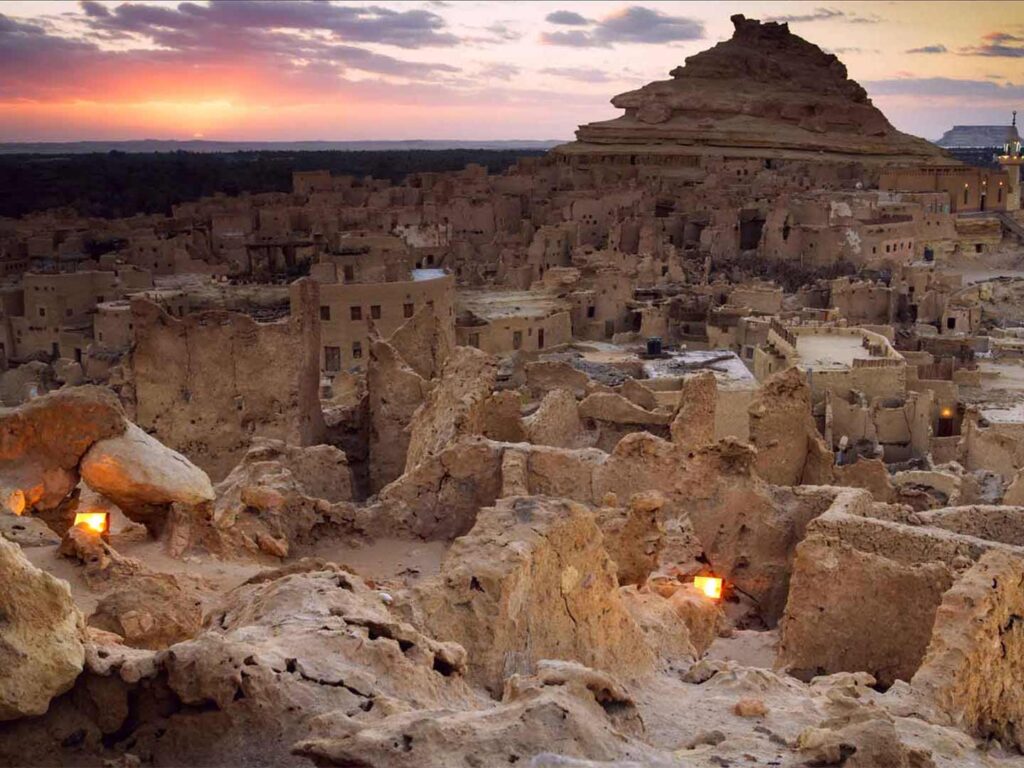 Evening atmosphere in the Siwa Oasis, Egypt. Individual lanterns burn between the clay houses