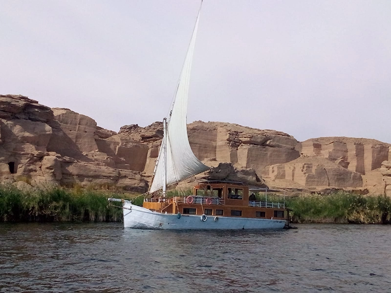 Egypt by boat: A small dahabeya (sandal) moves along the banks of the Nile